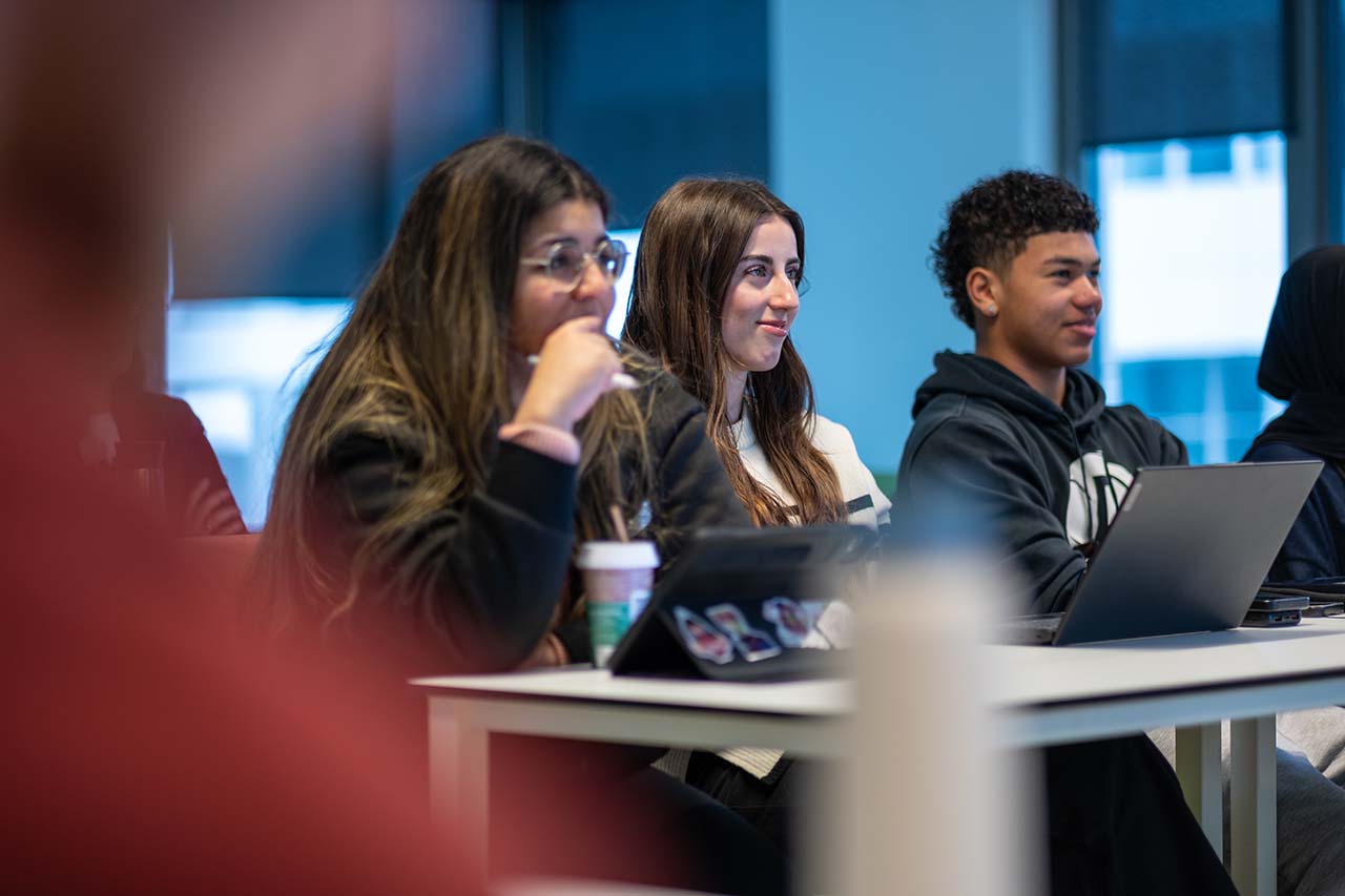 Drie PRE-studenten luisteren met plezier naar het college van voedselwetenschapper Laura.