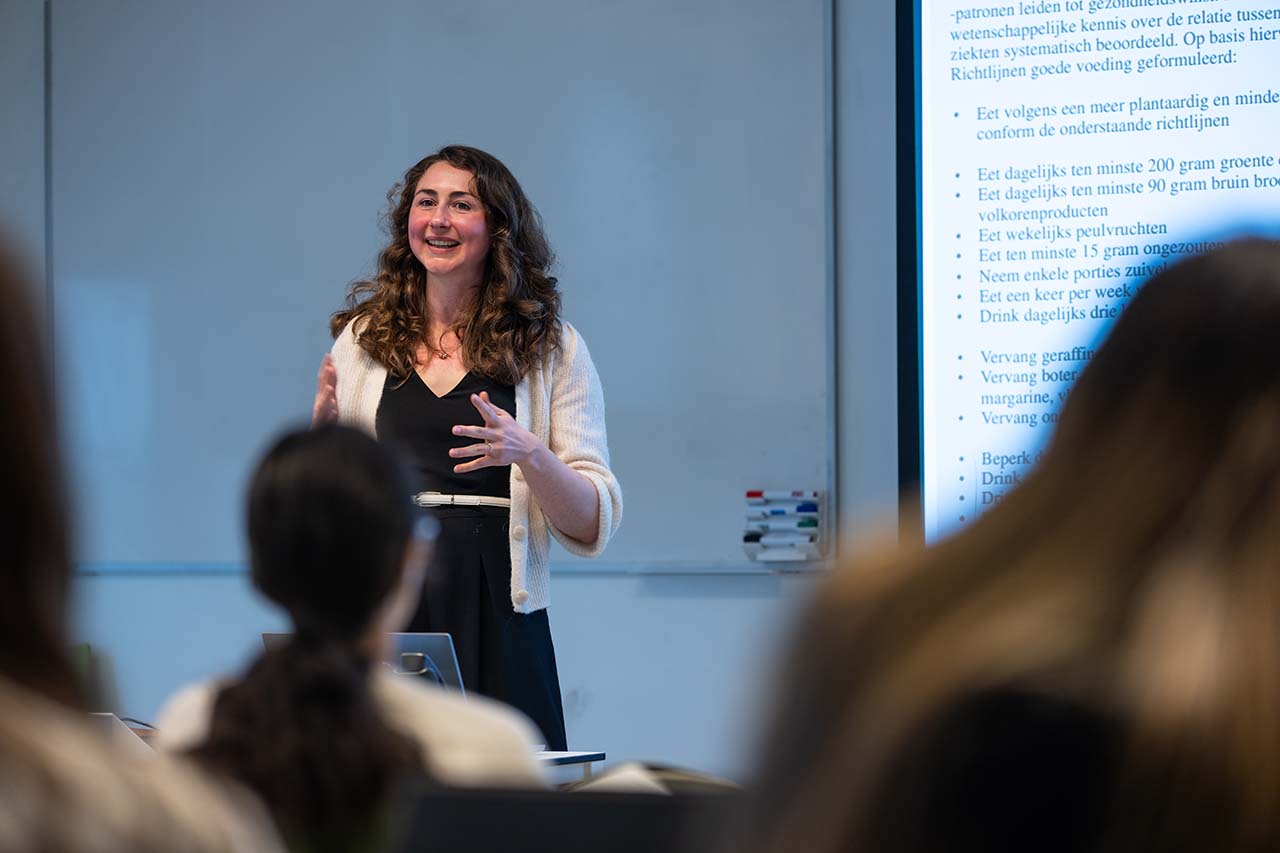 Voedselwetenschapper Laura van der Velde staat met een lach voor de klas.